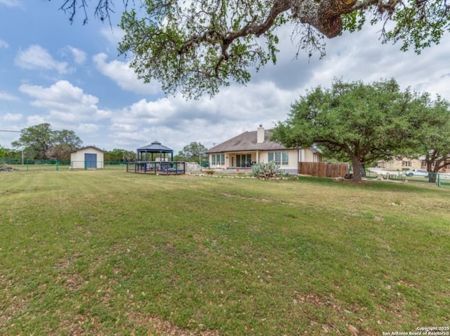 view of yard with an outbuilding, a storage shed, a gazebo, and fence