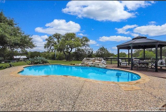 view of pool featuring a fenced in pool, a wooden deck, and a gazebo