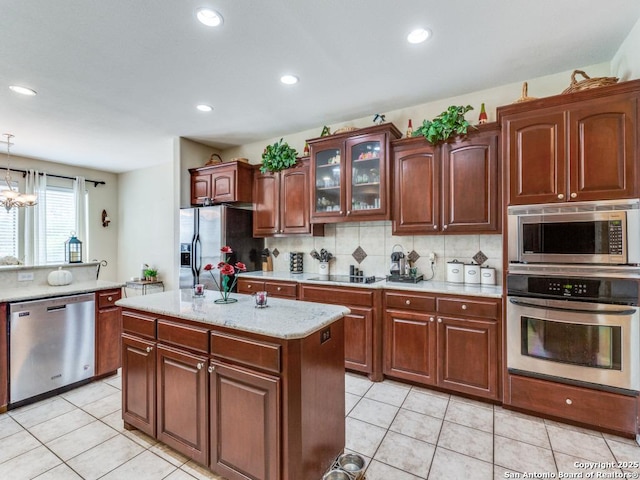kitchen with recessed lighting, stainless steel appliances, glass insert cabinets, and decorative backsplash