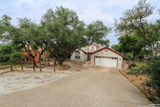 mediterranean / spanish house featuring fence, concrete driveway, an attached garage, and brick siding