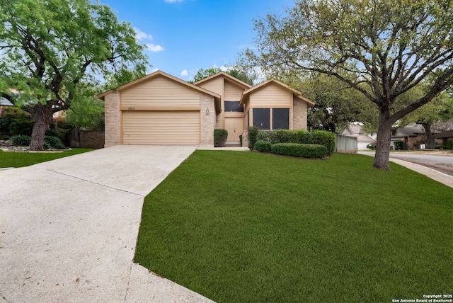 view of front of property featuring a front yard, driveway, a garage, and brick siding