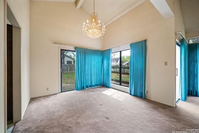 carpeted empty room featuring beam ceiling, high vaulted ceiling, and a notable chandelier
