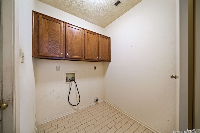 washroom featuring cabinet space, hookup for an electric dryer, washer hookup, baseboards, and a textured ceiling