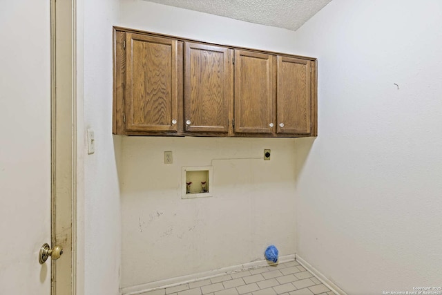 2915 Hunters Strm, San Antonio, TX 78230 - clothes washing area featuring electric dryer hookup, cabinet space, washer hookup, baseboards, and a textured ceiling