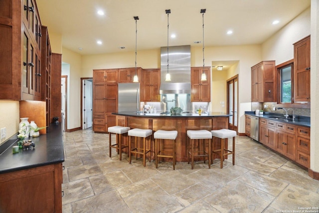 kitchen featuring a sink, stainless steel appliances, wall chimney exhaust hood, backsplash, and dark countertops