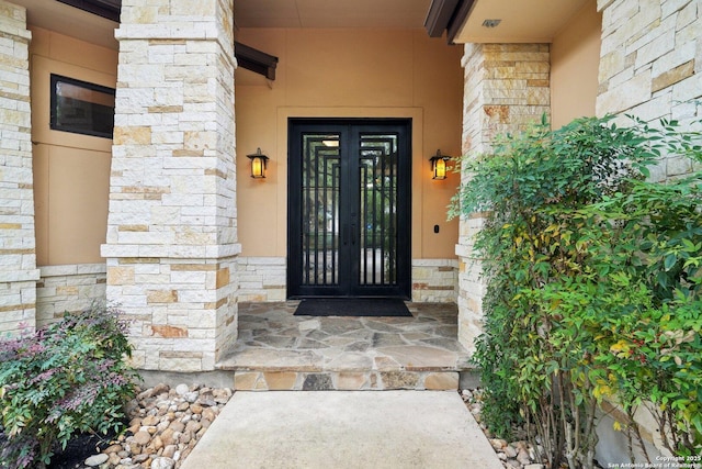 view of exterior entry with french doors and stone siding