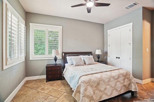 bedroom with baseboards, visible vents, and a ceiling fan