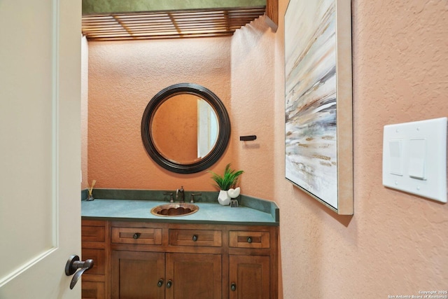 bathroom featuring a textured wall and vanity