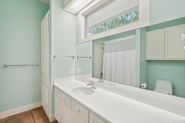 full bath with baseboards, tile patterned floors, toilet, and vanity