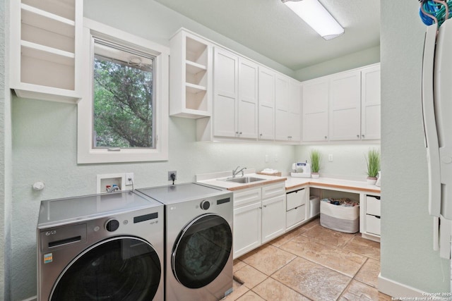 laundry room with independent washer and dryer, cabinet space, and a sink