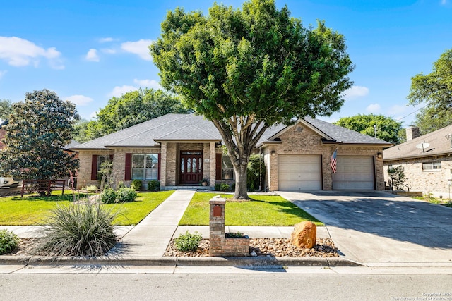 view of front of home featuring a front yard, concrete driveway, and brick siding