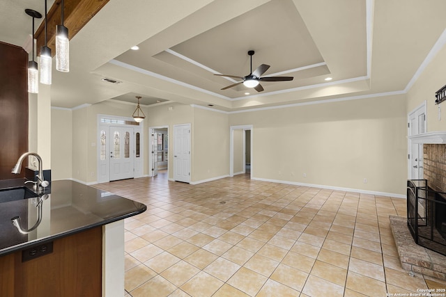 living room featuring light tile patterned floors, a raised ceiling, visible vents, baseboards, and a ceiling fan