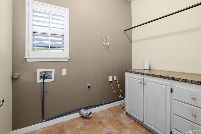 washroom featuring hookup for an electric dryer, light tile patterned floors, baseboards, hookup for a washing machine, and cabinet space