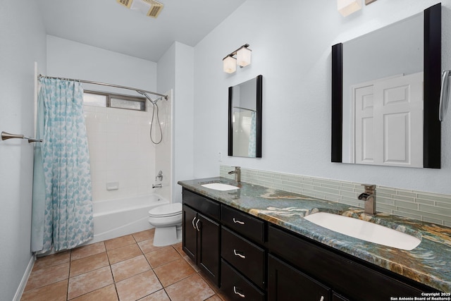 bathroom featuring toilet, double vanity, a sink, and visible vents
