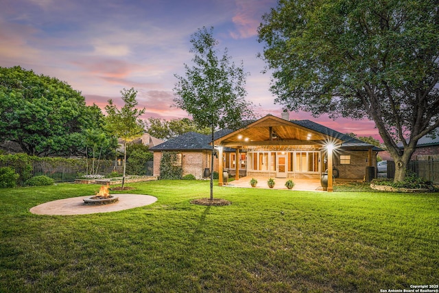 rear view of property with a patio, a chimney, an outdoor fire pit, a lawn, and fence private yard