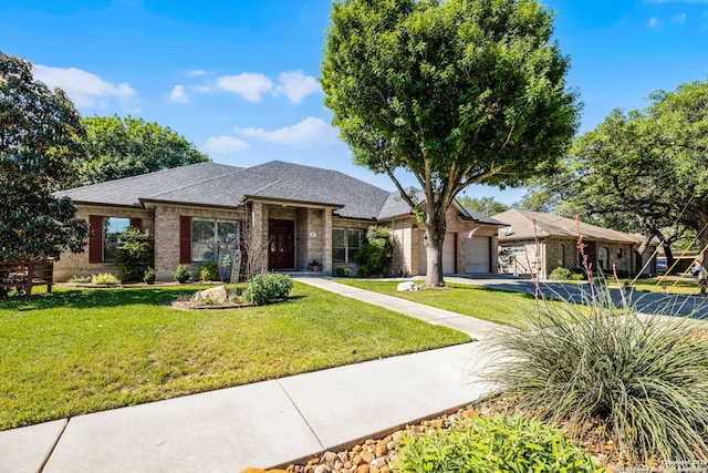 view of front facade featuring brick siding, a front yard, driveway, and an attached garage