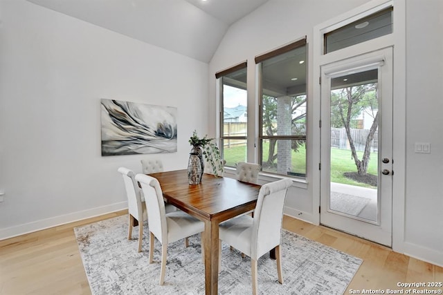 dining space with lofted ceiling, light wood-type flooring, and baseboards