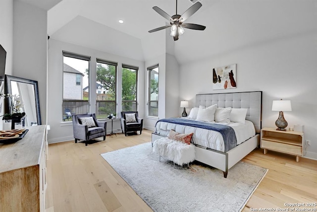 bedroom featuring light wood-style flooring, vaulted ceiling, and baseboards