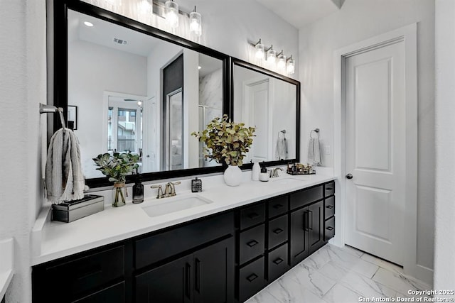 bathroom featuring double vanity, a sink, a shower stall, and marble finish floor