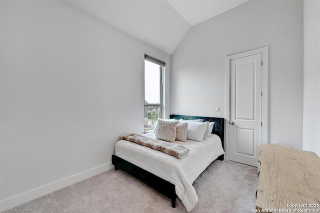 bedroom with baseboards, light colored carpet, and lofted ceiling