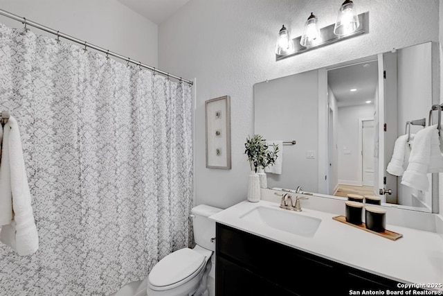 full bath with toilet, vanity, and a shower with shower curtain