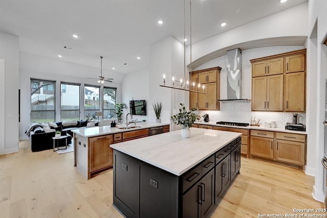 kitchen featuring a peninsula, ceiling fan, a center island, wall chimney exhaust hood, and dishwashing machine