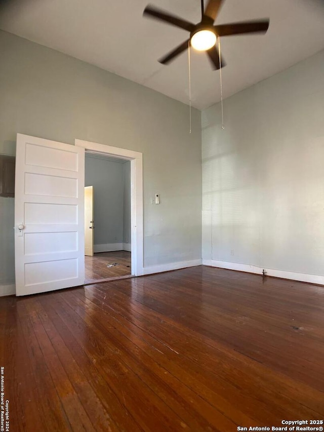 spare room with ceiling fan, wood-type flooring, and baseboards