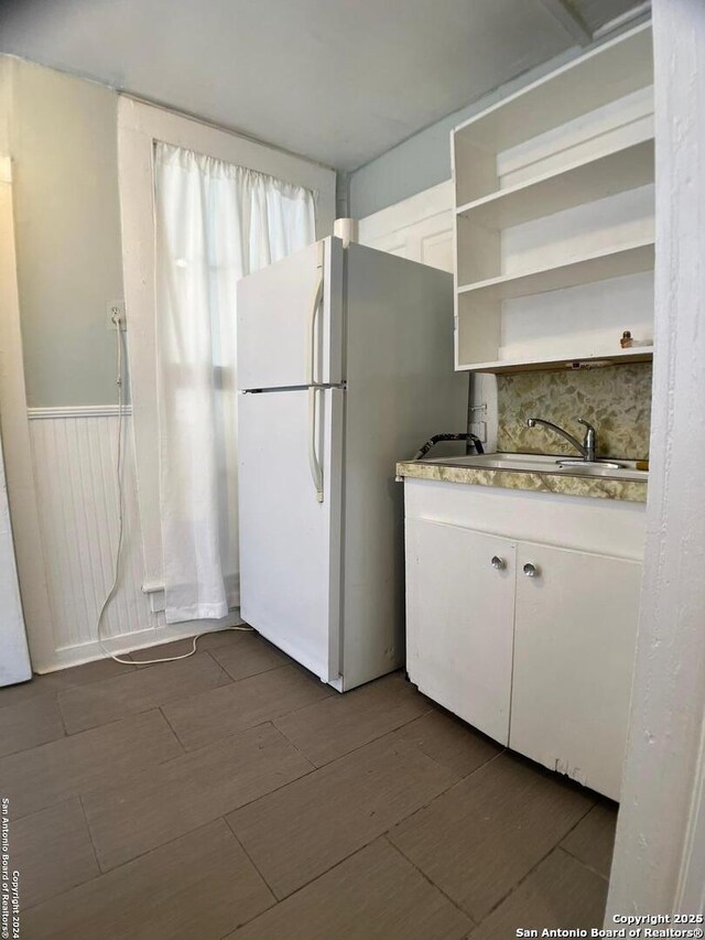 kitchen featuring dark wood-style flooring, white cabinets, and freestanding refrigerator