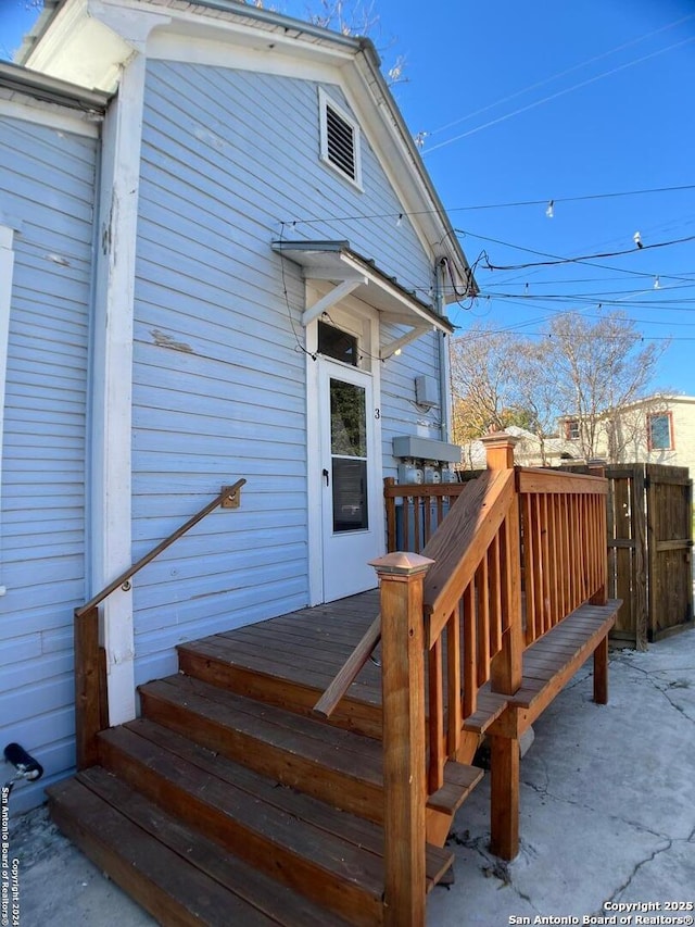 entrance to property with a wooden deck and fence