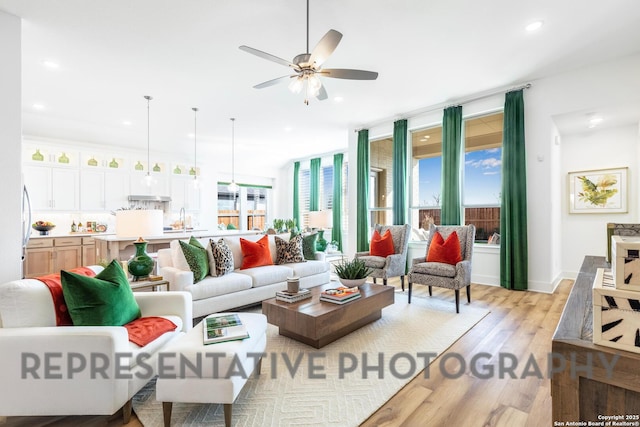 living room with light wood-style floors, plenty of natural light, a ceiling fan, and recessed lighting