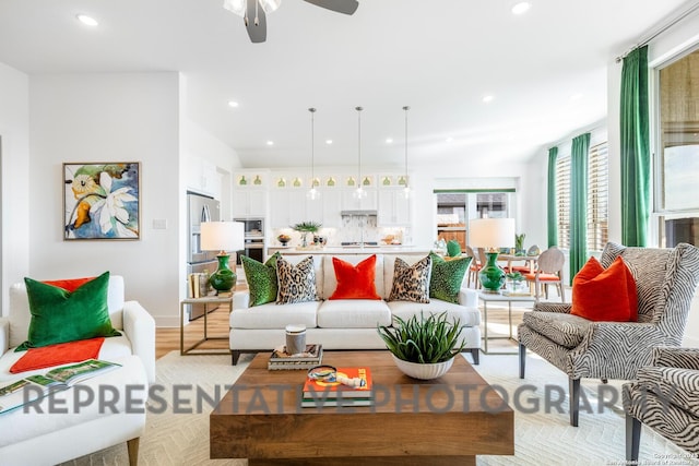 living room with baseboards, recessed lighting, a ceiling fan, and light wood-style flooring