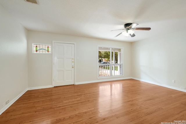 empty room featuring ceiling fan, baseboards, and light wood-type flooring