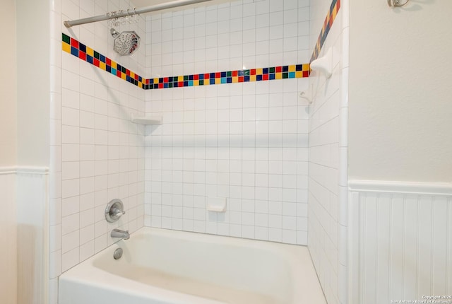 bathroom featuring wainscoting and shower / bath combination