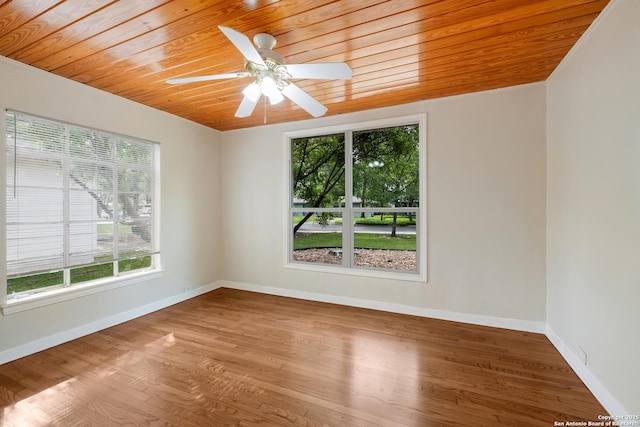 unfurnished room featuring baseboards, a wealth of natural light, wood finished floors, and wood ceiling