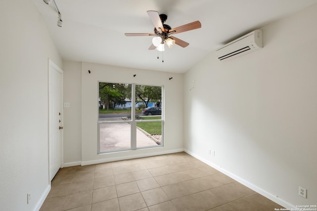tiled spare room featuring a ceiling fan, an AC wall unit, and baseboards