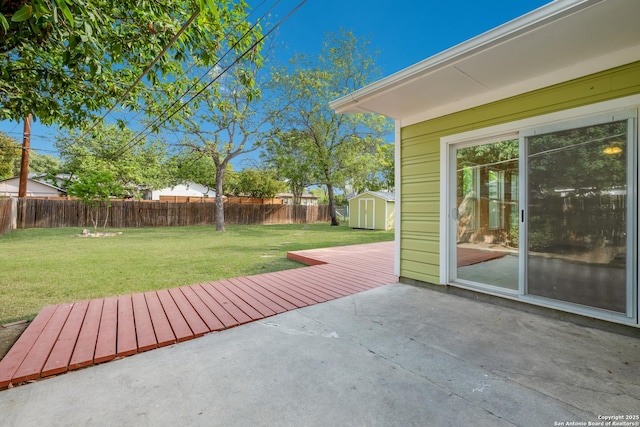 view of patio with an outdoor structure, a storage unit, and a fenced backyard