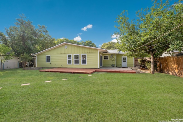 back of house featuring fence, a wooden deck, and a yard