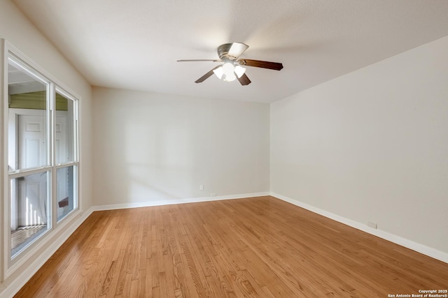 unfurnished room featuring baseboards, a ceiling fan, and light wood-style flooring