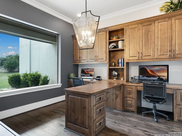 office space featuring crown molding, built in study area, dark wood-style flooring, and a chandelier