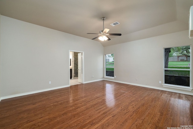 unfurnished room featuring a ceiling fan, visible vents, vaulted ceiling, baseboards, and wood finished floors