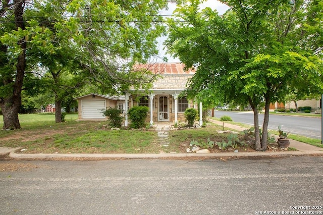 obstructed view of property featuring covered porch, a front lawn, and stone siding