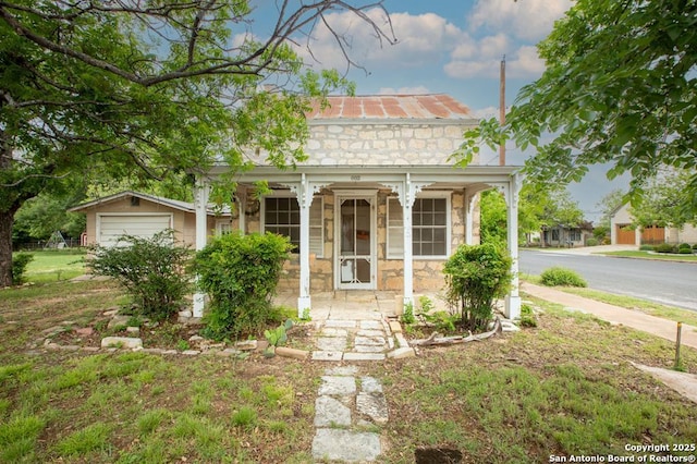 view of front of property with a porch, metal roof, and stone siding