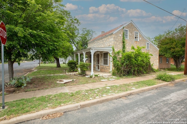 view of front of home featuring a porch and stone siding