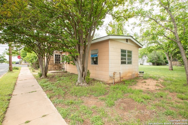 view of side of home with a lawn