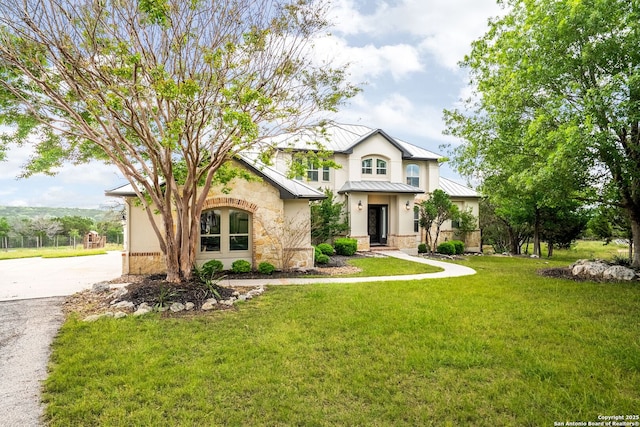 view of front of property featuring a front yard, a standing seam roof, metal roof, and stone siding