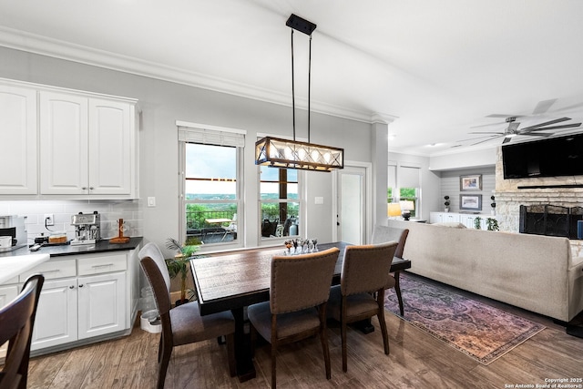 dining area featuring ornamental molding, plenty of natural light, a ceiling fan, and light wood-style floors