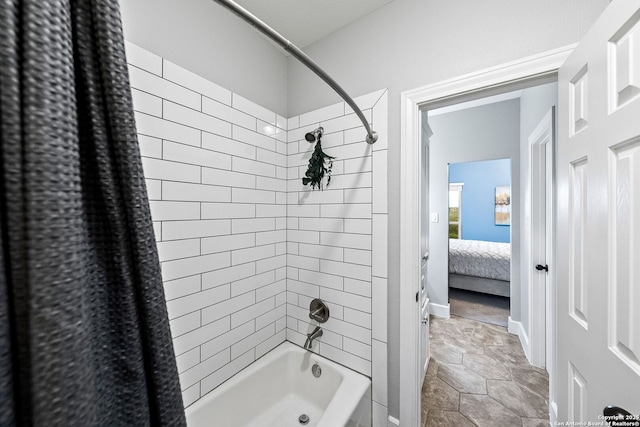 bathroom with shower / bath combo, ensuite bathroom, and stone finish flooring