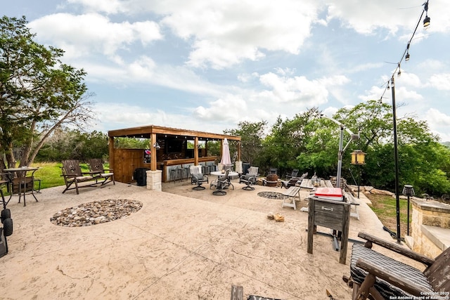 view of patio / terrace with outdoor dry bar and a fire pit