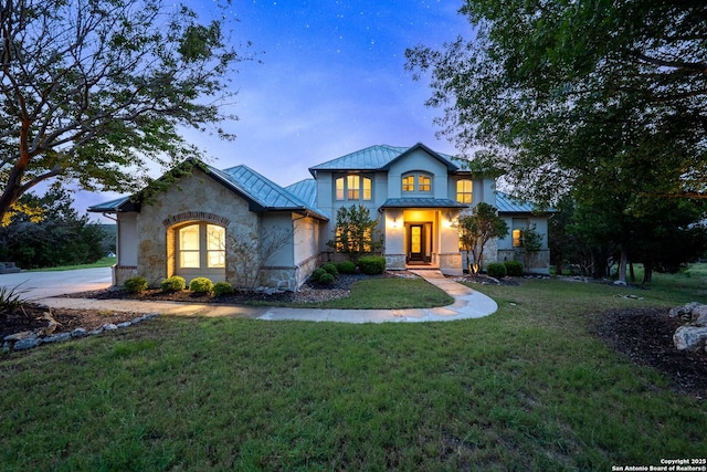 view of front of house with a front yard, a standing seam roof, metal roof, and stone siding