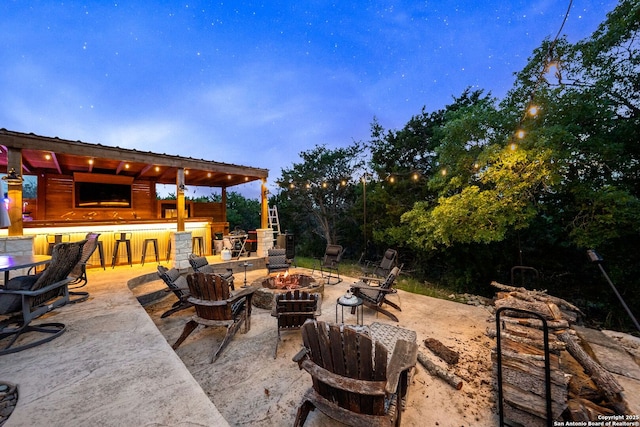 view of patio with outdoor dry bar and a fire pit